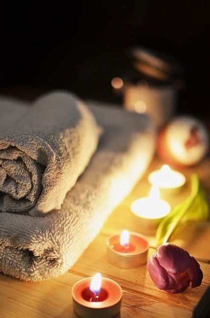 towel and lit candles set up in a massage room