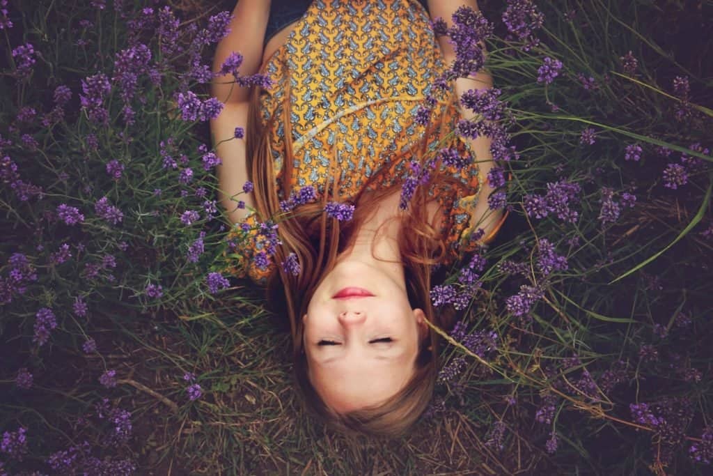 woman laying in a field of purple flowers