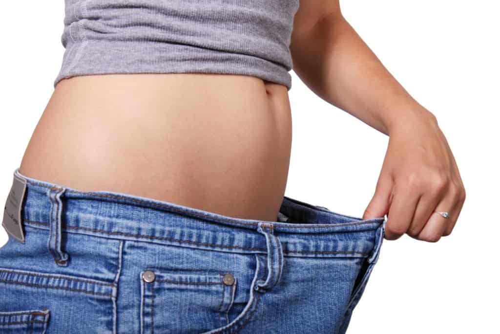 woman stretching out her pants showing weight loss