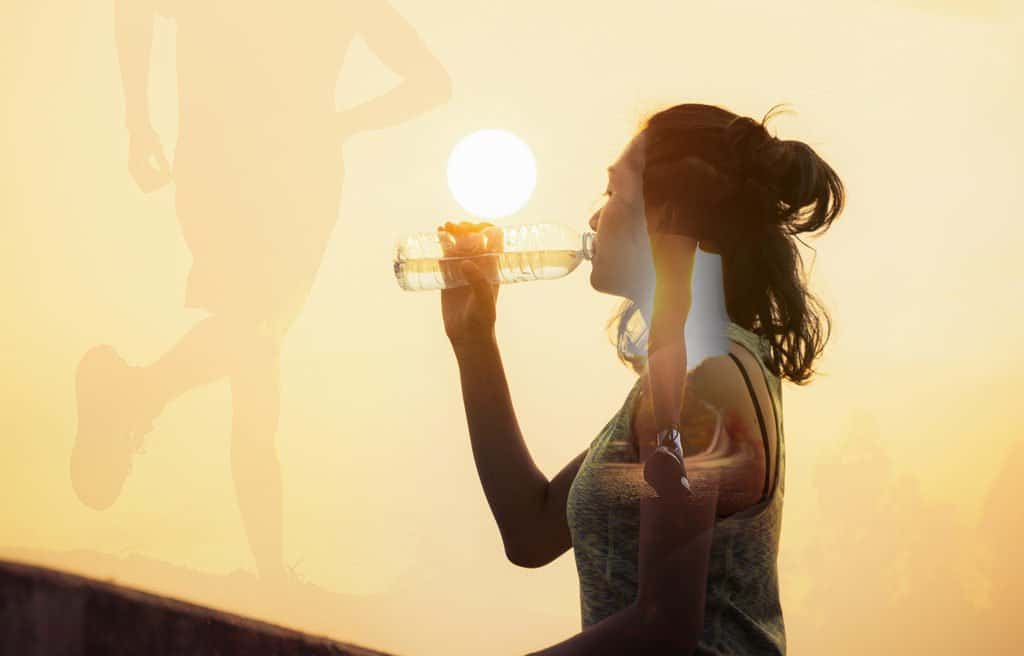woman drinking water after a workout