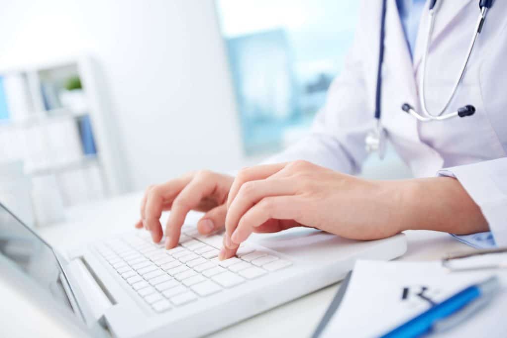 close-up-of-hands-of-a-nurse-typing-on-laptop